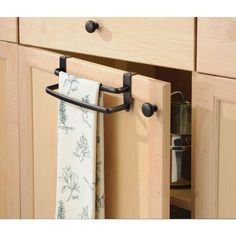 a kitchen cabinet door is open to reveal a towel rack