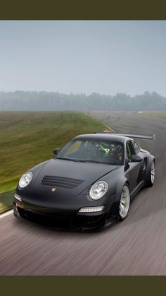 a black sports car driving down the road