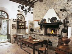 an old fashioned dining room with stone fireplace