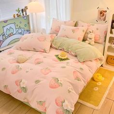 a bed with pink and green strawberry print on it