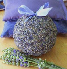 lavender flowers are sitting on the table next to a pillow and a ball with a bow