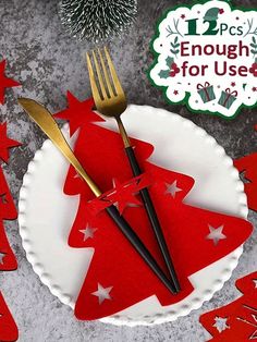 a plate with two forks and a red christmas tree cutout on it next to a holiday decoration