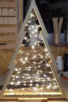 a wooden christmas tree with lights on it