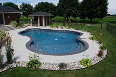 a backyard with a swimming pool and landscaping