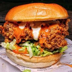 a chicken sandwich with lettuce and tomato sauce