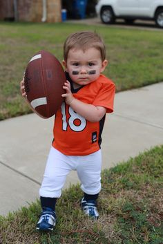 a young boy holding a football in his hands