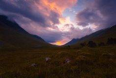 the sky is filled with colorful clouds over mountains