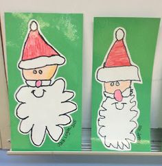 two paper cut outs with santa and snowmen on them, hanging from the wall