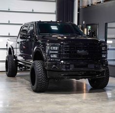 a large black truck parked in a garage