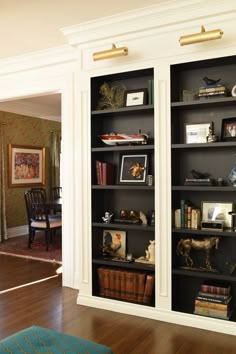 an empty bookcase with books and pictures on the shelves in a living room area