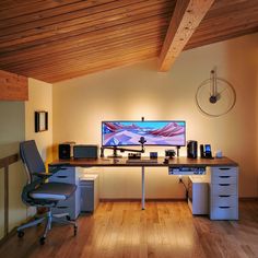 a desk with two chairs and a computer monitor on top of it in a room