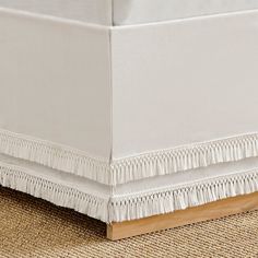 a close up view of a white bed skirt