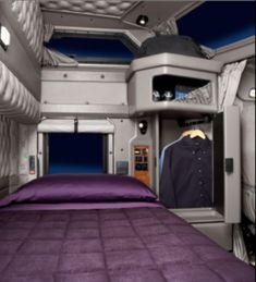 the inside of a space shuttle with a bed and purple bedspread