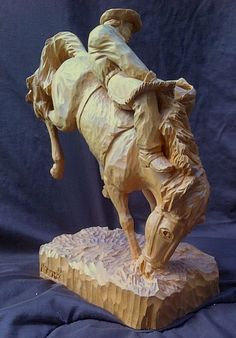 a wooden sculpture of a man riding a horse