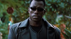 a man wearing sunglasses and a leather jacket