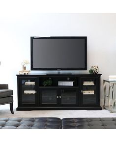 a flat screen tv sitting on top of a black entertainment center in a living room