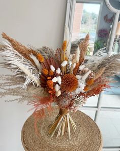 a vase filled with dried flowers on top of a table