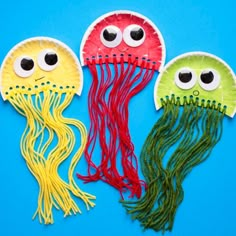 paper plate jellyfish craft for kids with googly eyes and hair on blue background