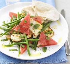 a white plate topped with green beans and watermelon