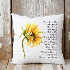 a white pillow with a yellow sunflower on the front and poem written in cursive writing