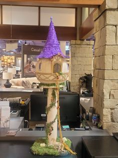 a tall tower with a purple hat on it's top sitting in a store