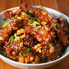 a bowl filled with meat covered in sesame seeds