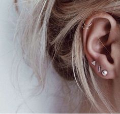 a woman's ear with two piercings on it