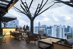 people are sitting at an outdoor bar overlooking the city