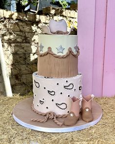 a three tiered cake with baby booties on the bottom and stars on top