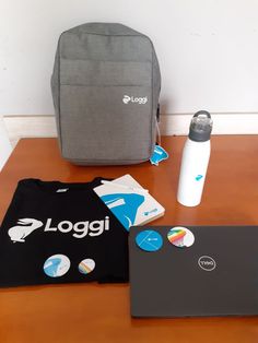 a laptop, backpack and t - shirt sitting on a table with the logos printed on it