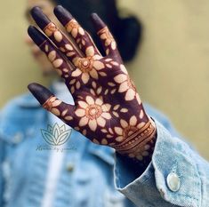 a close up of a person's hand with hennap and flowers on it