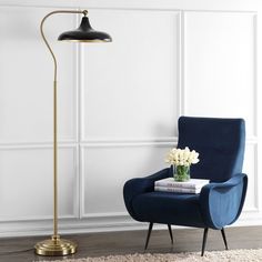 a living room with a blue chair and a gold floor lamp