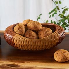 a wooden bowl filled with cookies on top of a table