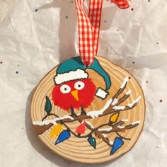 a wooden ornament with a bird on it's head and a red ribbon