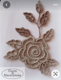 a crocheted rose is shown on a white surface with the words, oopsta macarymosa