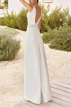 a woman in a white dress standing on a wooden deck