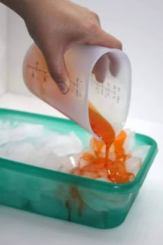 someone pouring orange juice into a container