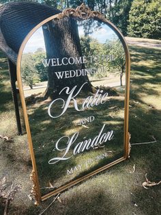 a mirror that is sitting on the ground in front of a tree and some grass