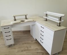 an office desk with drawers and two laptops on it