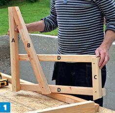 a man standing next to a wooden frame