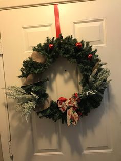 a christmas wreath hanging on the front door