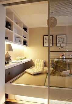 a room with a bed, shelves and pictures hanging on the wall in front of it