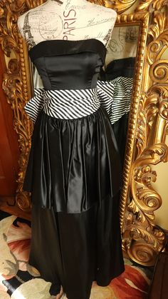 "This beautiful prom dress is from the 80's by Jessica Mc Clintock.  This is a high quality gown in excellent condition!  Made of lucious black satin with a wide striped cumberbund waist. Beautiful large bow on the back that secures with a snap on one side. Strapless style with a wide cuff around the top.  Fitted bodice with boning for stability. Tired skirt.  There is an under layer with tulle at the bottom for shape.  It is labeled a size 7, however, it fits smaller through the bust. Please see the measurements below for a proper fit.  All sales are final. Measurements Bust 30\" Waist 26\" Length from top of back 48\"" Jessica Mcclintock Wedding Dress, Tired Skirt, Beautiful Prom Dress, Fashion 1980s, Beautiful Prom Dresses, Polyester Pants, Jessica Mcclintock, Wide Stripes, Gunne Sax