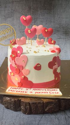 a white and red cake with hearts on top