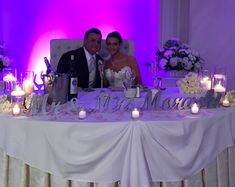 a bride and groom sitting at a table with candles