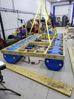 an assembly line in a warehouse with blue barrels and yellow tape on the floor,