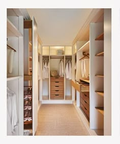 a walk in closet with white walls and drawers