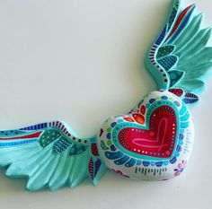 a decorative heart shaped bird hanging on the wall