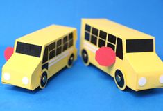 two yellow school buses are on a blue surface