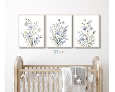 three floral paintings on the wall above a crib